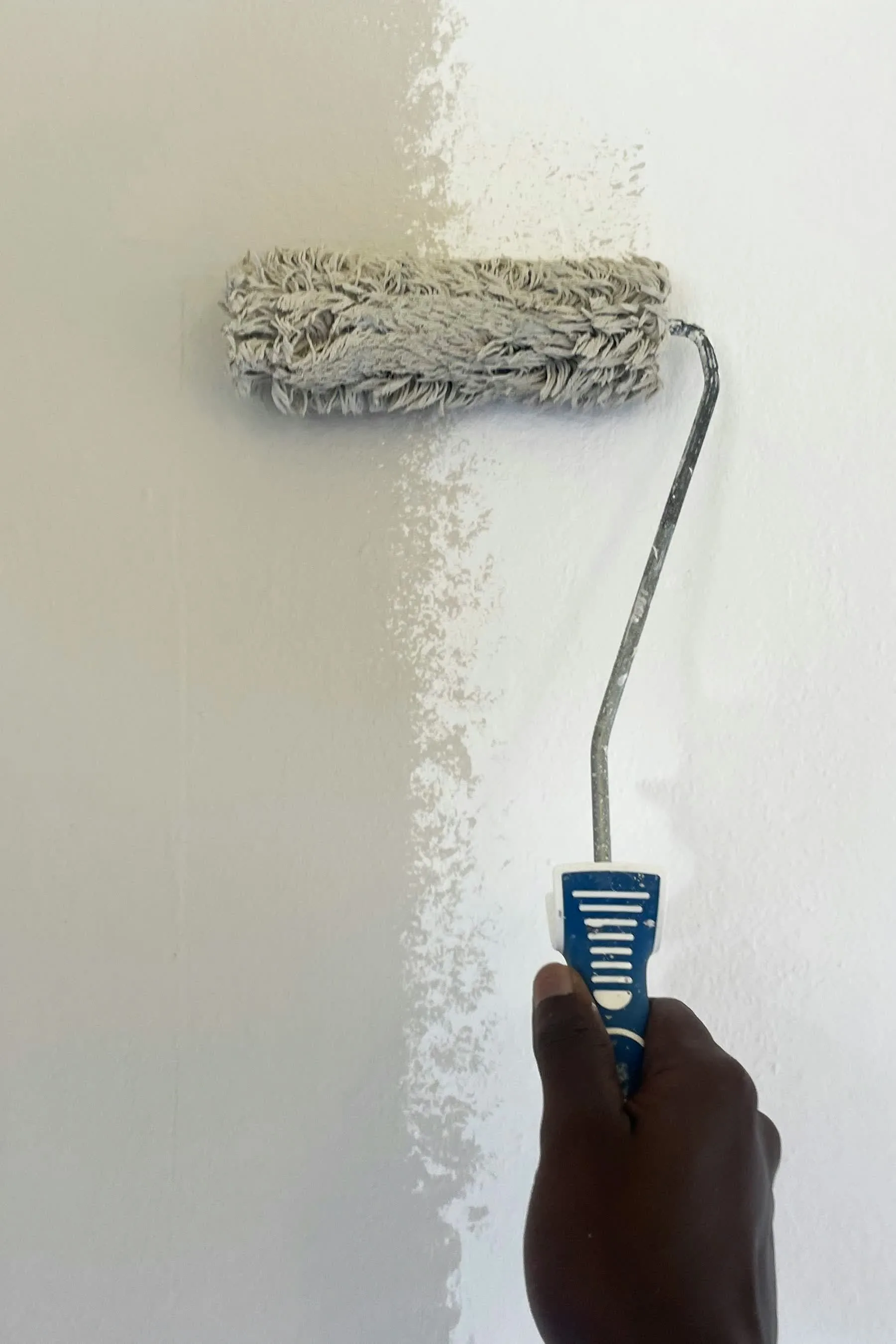 Paint roller cutting a clean line on a freshly painted wall