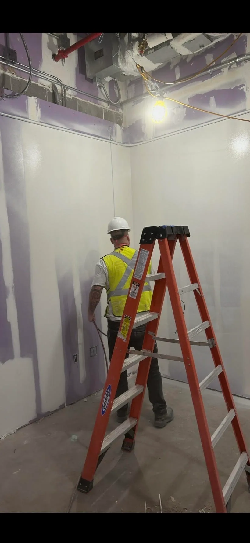 SCG crew member preparing walls for paint on a commercial job site