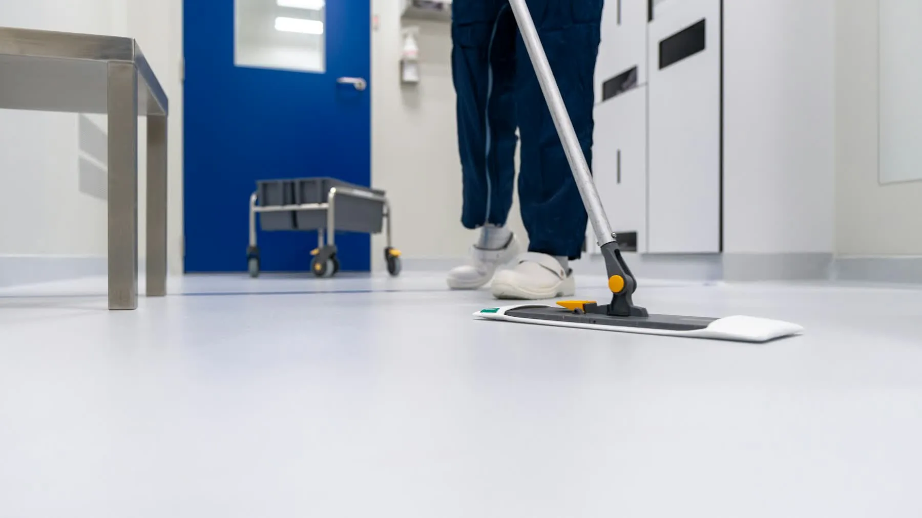 Professional cleaner mopping a bright, spotless commercial interior floor