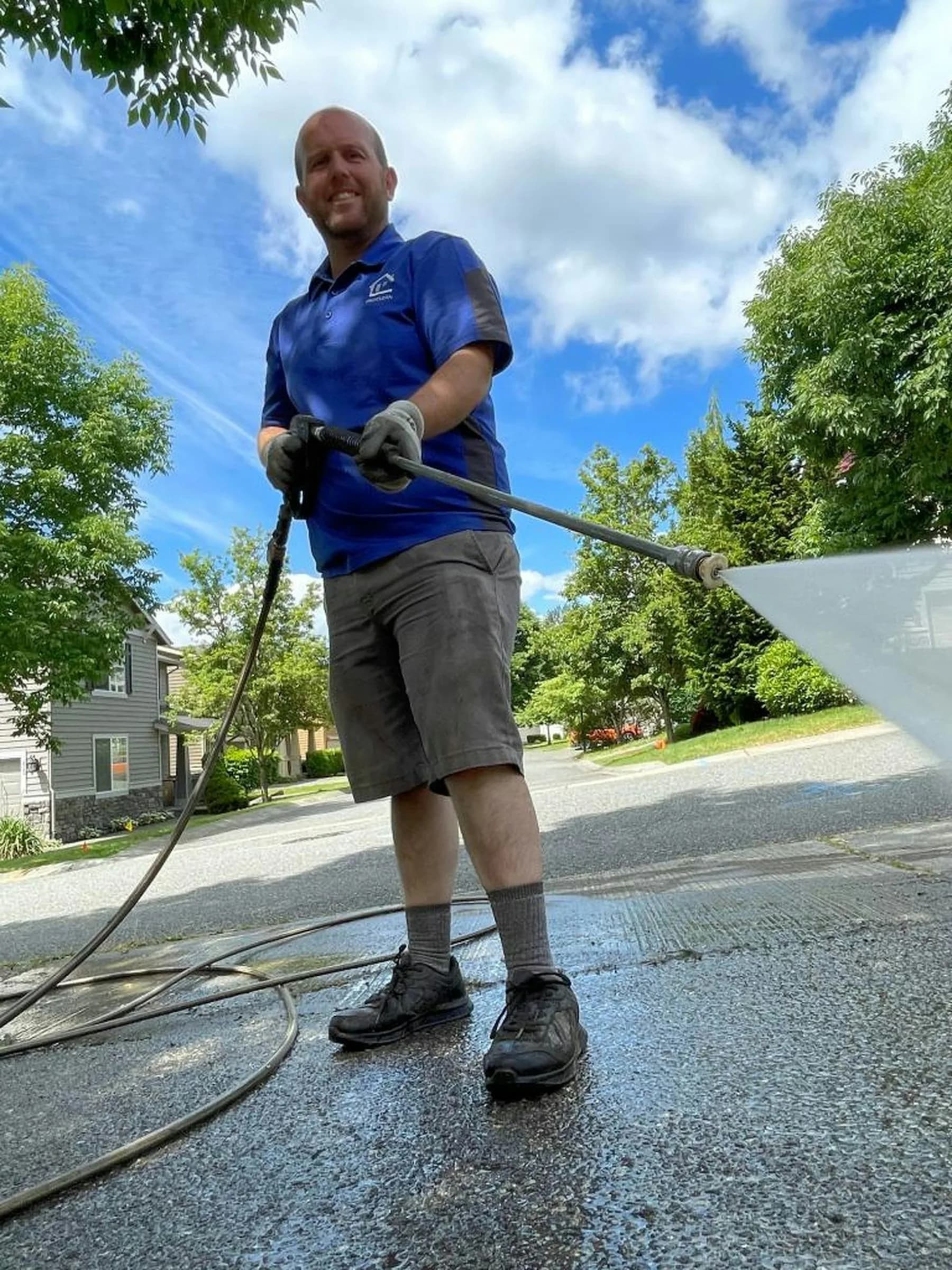 Driveway being pressure washed, clean concrete next to dirty concrete